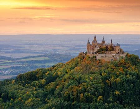 Burg Hohenzollern auf Berg mit Wald beim Sonnenuntergang