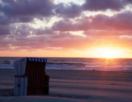 Strandkorb am Meer mit Sonnenuntergang